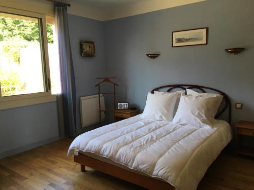 サン・リュネールにあるLa maison des couleursの白いシーツと窓のあるベッドのある寝室