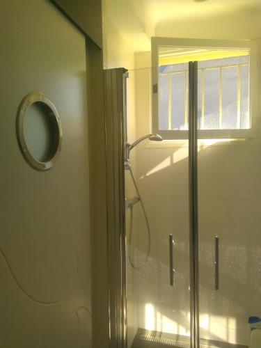 La salle de bains est pourvue d'une douche et d'un miroir. dans l'établissement La maison des couleurs, à Saint-Lunaire