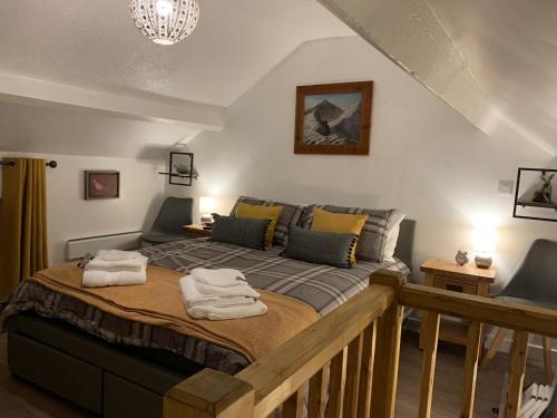 a bedroom with a bed with two towels on it at Delightful One Bed Lake District Cottage in Penrith