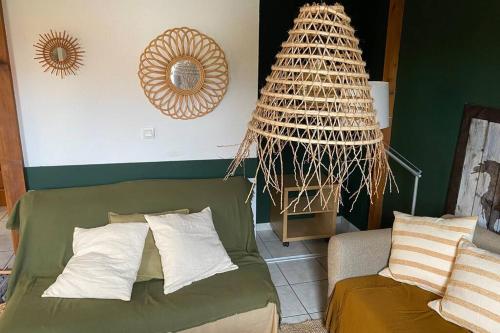 - un salon avec un canapé vert et un miroir dans l'établissement Maison au coeur des Landes, Saint-Julien en Born, à Saint-Julien-en-Born