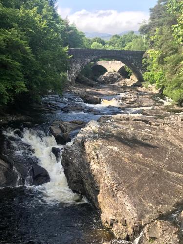 a bridge over a river with a waterfall at Whitebridge Hotel in Whitebridge