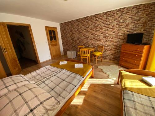 a bedroom with two beds and a brick wall at Noclegi u Wojtka in Sromowce Wyżne