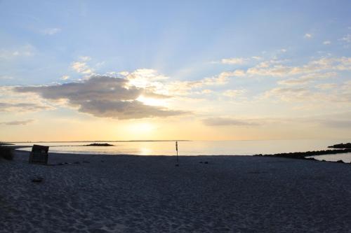 a view of a beach with the sun setting at Apartment Wuhrt in Barsbek