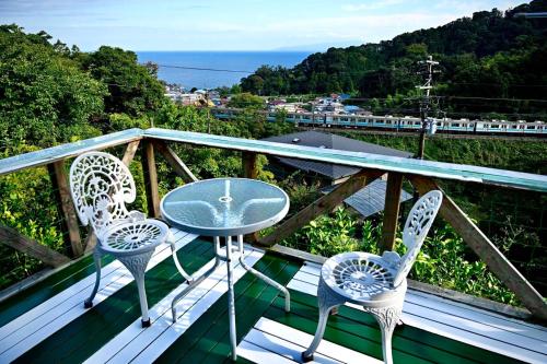 a table and two chairs on a balcony with a view at Breathtaking View House in Ito