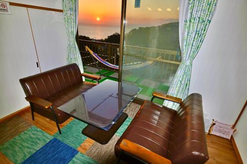 a living room with a couch and a glass window at Breathtaking View House in Ito