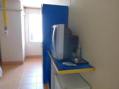 een computermonitor op een blauw aanrecht in een kamer bij Silver Reef in Udon Thani