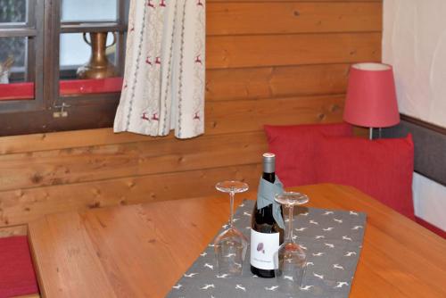 a bottle of wine and two glasses on a table at Apartment Sonnleitn/Nassfeld in Sonnenalpe Nassfeld