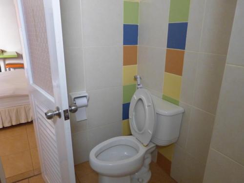 a bathroom with a toilet and a colorful wall at Silver Reef in Udon Thani