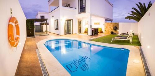 a villa with a swimming pool in front of a house at Villa Garoed in Playa Blanca
