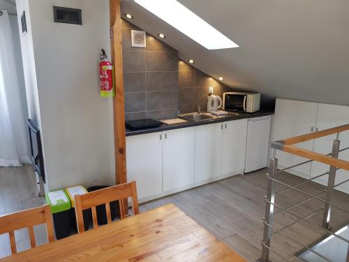 a small kitchen with white cabinets and a microwave at Świerkowe Zacisze Nałęczów in Nałęczów