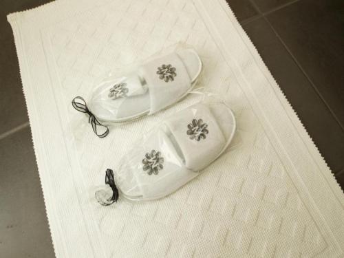 two white shoes with flowers on them on a table at The Manse in Maraekakaho