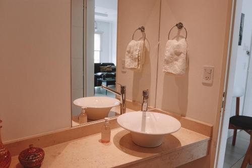 un bagno con due lavandini e un grande specchio di Administración MAIPU 2E DEPTO PREMIUM a Tandil