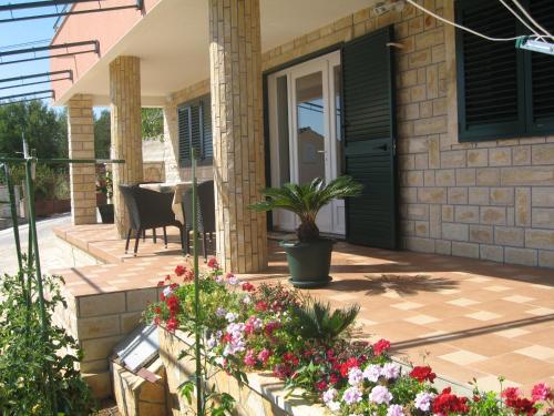 a front porch of a house with flowers at Apartments Hari Tisno in Tisno