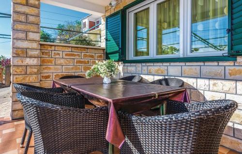 Une table et des chaises en bois sont disponibles sur la terrasse. dans l'établissement Apartments Hari Tisno, à Tisno