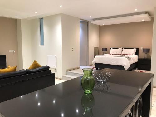 uma sala de estar com um sofá e uma cama em The Franklin Luxury Apartments em Joanesburgo