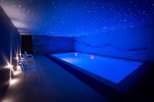 una piscina con iluminación azul en una habitación en Octavie - Suite de luxe à Tournai avec piscine privée, jacuzzi, sauna et hammam en Tournai