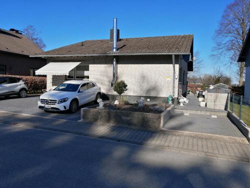 a white car parked in front of a house at Ferienwohnung Monecke in Hürtgenwald