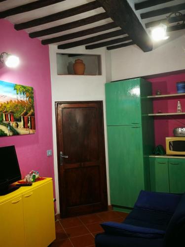 a room with pink and green walls and a door at ALLOGGIO S.ANNA in Isola del Giglio