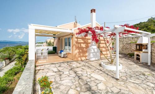 a small house with a porch with a view of the ocean at The Kantada Villas Petros, Eleni, Stelios & Dioni in Gaios