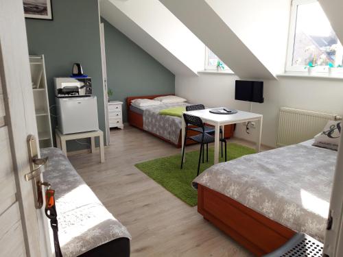 a room with two beds and a table and a desk at Azalia 32 Mielno l in Mielno