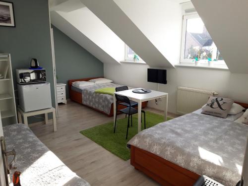 a room with two beds and a table with a desk at Azalia 32 Mielno l in Mielno