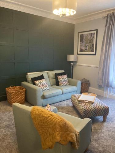 a living room with two couches and a person laying on a couch at Abbey Court Guest House in Carlisle