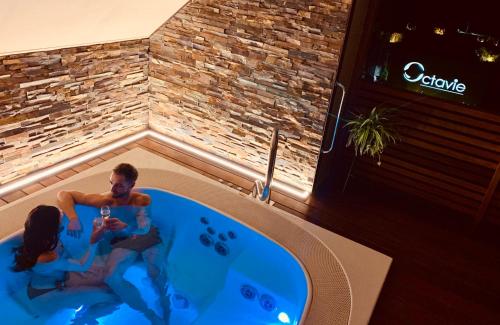 a man and a woman in a bath tub at Octavie - Suite de luxe à Tournai avec piscine privée, jacuzzi, sauna et hammam in Tournai