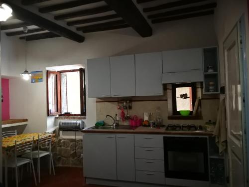 a kitchen with white cabinets and a counter top at ALLOGGIO S.ANNA in Isola del Giglio