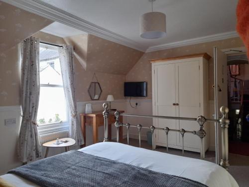 1 dormitorio con cama y ventana en Buchan Guest House en Moffat