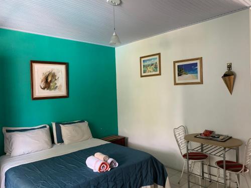 um quarto com uma cama e uma parede verde em Amanda Suites em Manaus