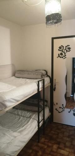 une chambre avec deux lits superposés et un miroir dans l'établissement Le Bora-Bora, à Marseillan