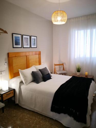 a bedroom with a large bed with black and white pillows at Medina Baguh (VFT) in Priego de Córdoba