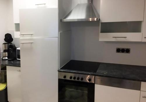 una cucina con mobili bianchi e un forno a piano cottura di Ferienwohnung Angelika a Degerfelden