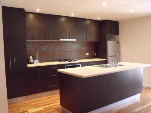a kitchen with black cabinets and a white counter top at Chill Apartment in Rye