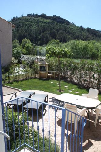 un patio avec une table et une table et des chaises dans l'établissement Villa Prestige côté calme du domaine de vacances - 8 pers 4 ch 2 sdb 120m2, à Vidauban