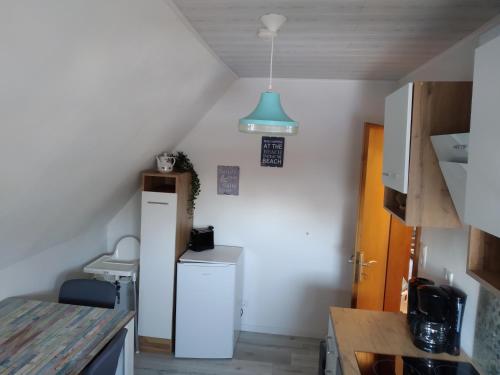 a small kitchen with a refrigerator and a blue light at Ferienwohnung Braun 'Haus Fidi' in Borkum