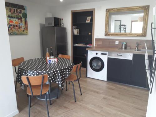 une cuisine avec une table et une machine à laver dans l'établissement La petite brise, à Plouër-sur-Rance
