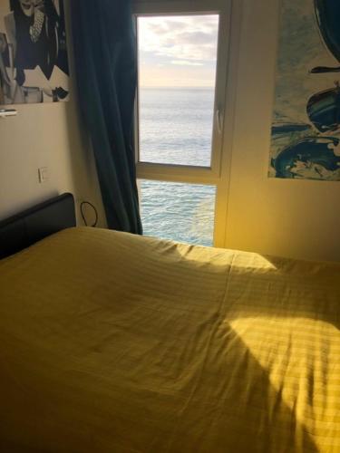 1 dormitorio con cama y ventana en Appartement cosy les pieds dans l’eau, vue mer exceptionnelle, en Crozon
