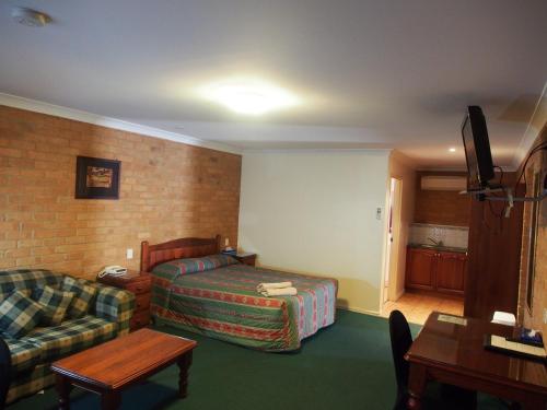 a hotel room with a bed and a couch at Cobar Town & Country Motor Inn in Cobar