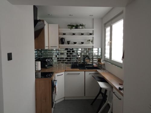 a kitchen with white cabinets and a table and a window at Apartament Romantyczny in Sandomierz