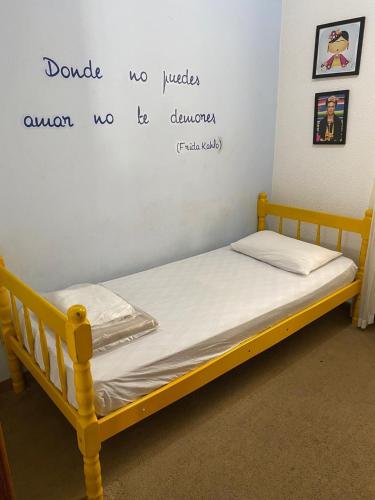 a bed in a room with a writing on the wall at Pousada Santa Lolla in São Carlos