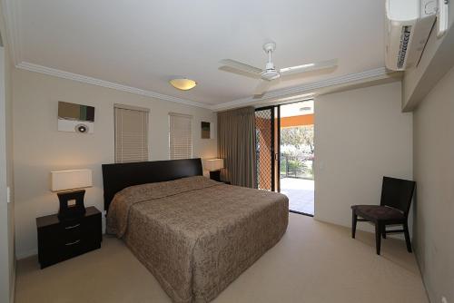 a bedroom with a bed and a ceiling fan at Pacific Reef by Kacys in Bargara