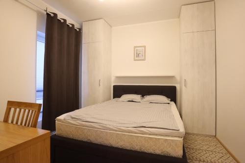 een slaapkamer met een bed in een kamer met een raam bij Aatrium Kinnisvara Kristalli str apartment Lõunakeskuse lähistel in Tartu