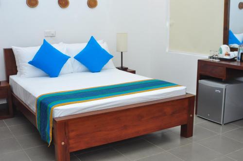 a bed with blue pillows in a room at Comfort@15 Hotel Colombo in Colombo