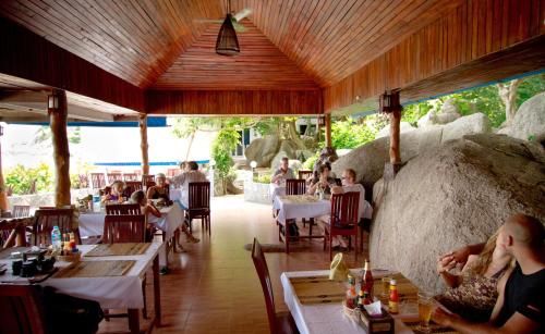 a group of people sitting at tables in a restaurant at Montalay - Eco Cottage Koh Tao in Ko Tao