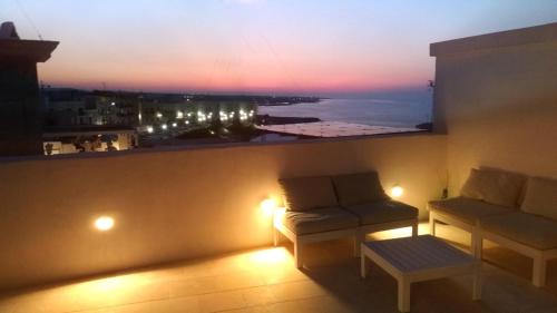 a room with a couch and a window with a view at FONTEblu B&B in Polignano a Mare