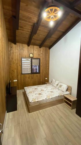 a bedroom with a large bed and a chandelier at Casa de lemn in Corbu