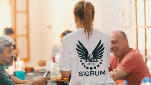 a woman in a group of people sitting at a table at SIGRUM Hostel in San Rafael