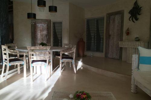 a living room with a dining room table and chairs at Fortamu - Tembo House in Watamu