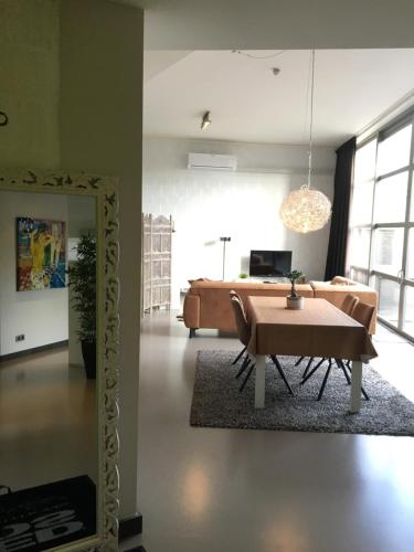 a living room with a table and a couch at WELLNESSLOFT in De Haan